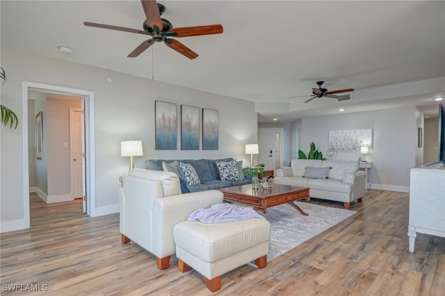 living room with light hardwood / wood-style flooring and ceiling fan