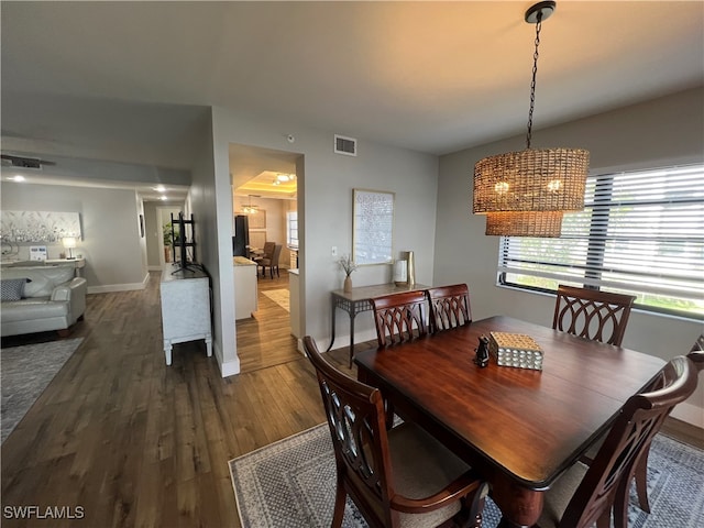 dining space featuring wood-type flooring and a chandelier