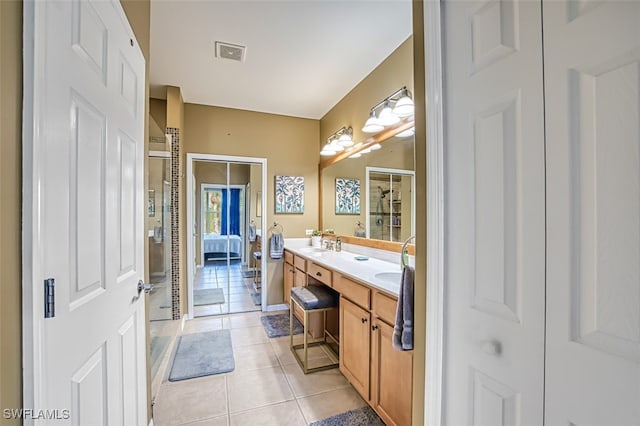 bathroom featuring tile patterned flooring, vanity, and walk in shower