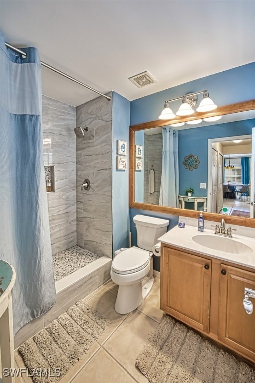 bathroom with tile patterned flooring, a shower with curtain, vanity, and toilet