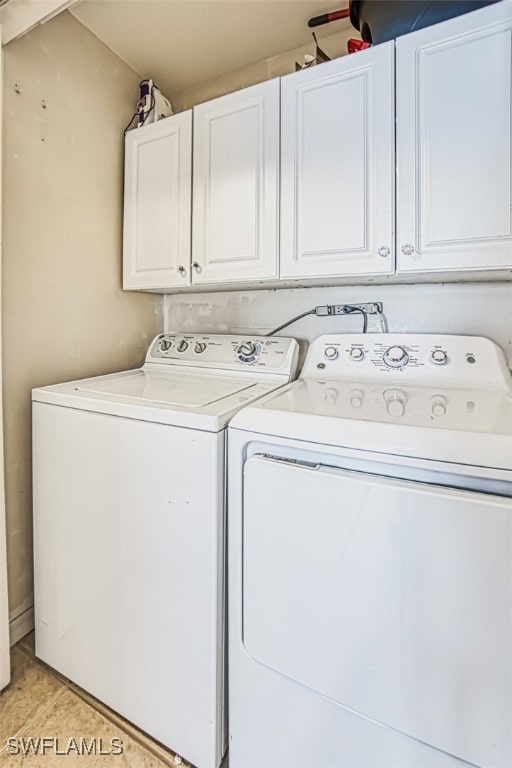 washroom with cabinets and washing machine and clothes dryer