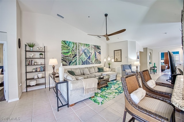 living room with lofted ceiling, ceiling fan, and light tile patterned floors