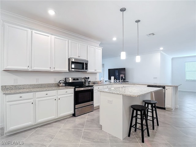 kitchen featuring kitchen peninsula, appliances with stainless steel finishes, white cabinets, and a kitchen island