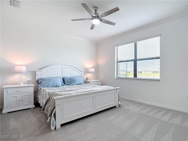 carpeted bedroom with ceiling fan and ornamental molding