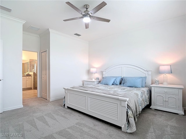 carpeted bedroom with ensuite bathroom, ceiling fan, and ornamental molding