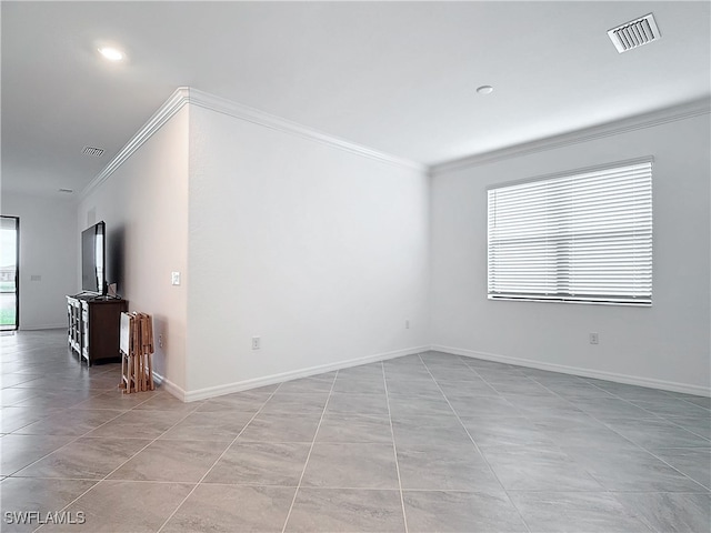 spare room featuring light tile patterned floors, plenty of natural light, and ornamental molding