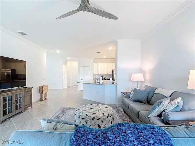 tiled living room with ceiling fan and crown molding