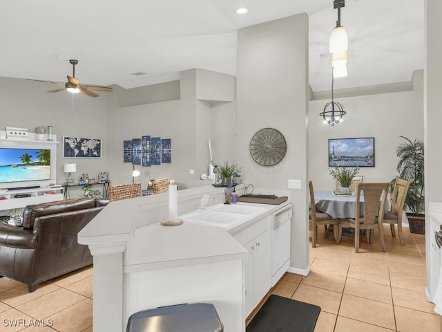 kitchen featuring ceiling fan with notable chandelier, sink, light tile patterned floors, dishwasher, and hanging light fixtures