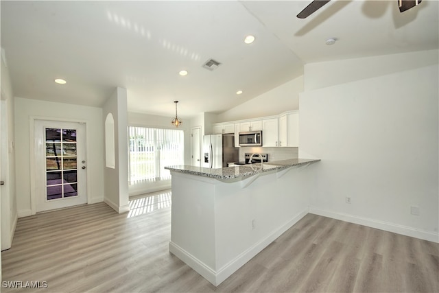 kitchen featuring stainless steel appliances, light hardwood / wood-style floors, white cabinetry, hanging light fixtures, and lofted ceiling