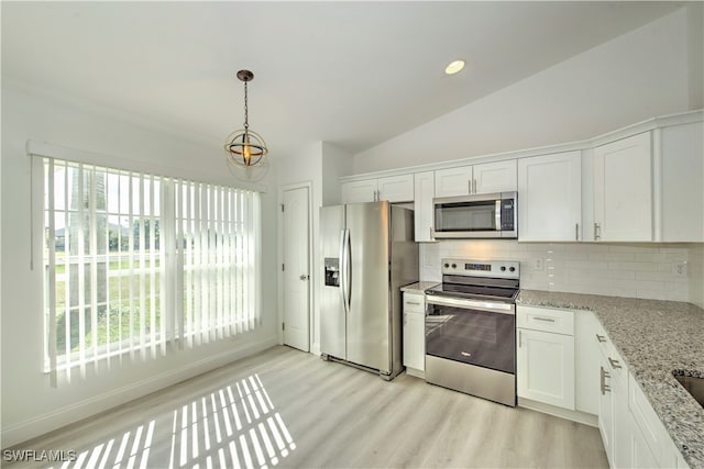 kitchen with plenty of natural light, white cabinetry, stainless steel appliances, and vaulted ceiling