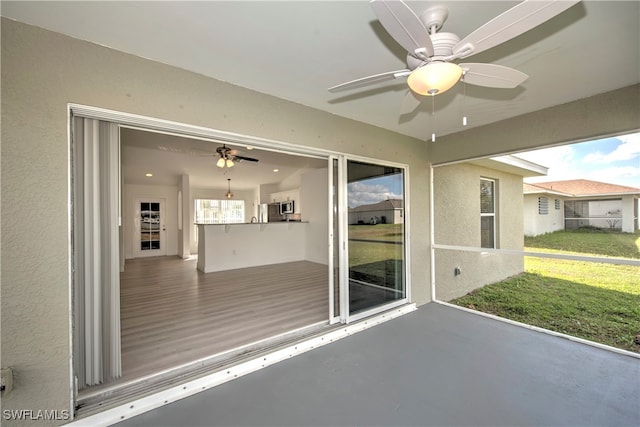 unfurnished sunroom with ceiling fan