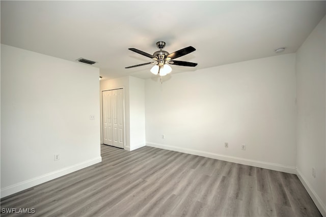 empty room with ceiling fan and light hardwood / wood-style flooring