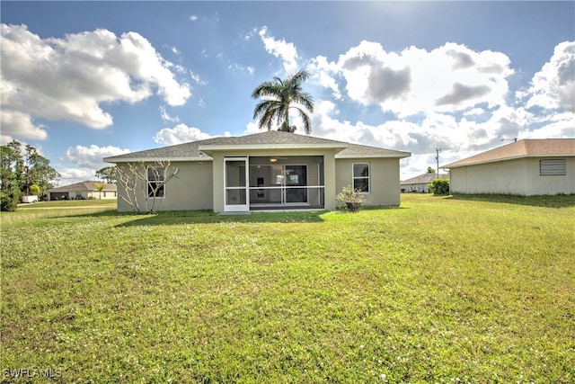 back of property with a sunroom and a lawn