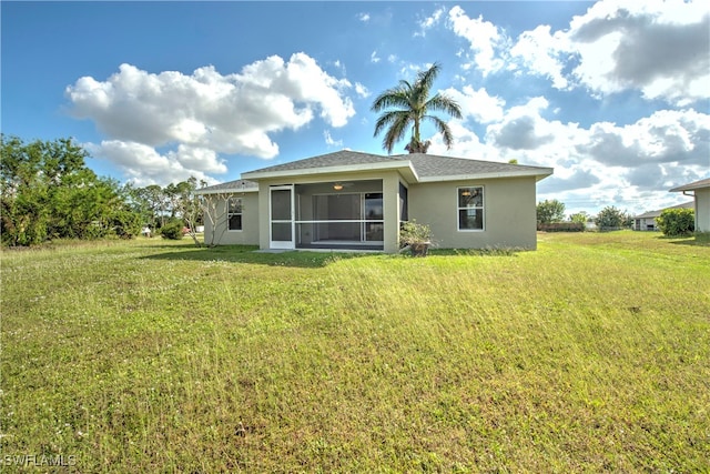 rear view of house with a sunroom and a yard