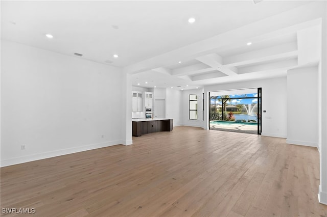 unfurnished living room with beamed ceiling, light wood-type flooring, and coffered ceiling