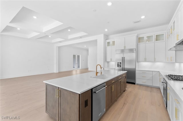 kitchen featuring white cabinetry, a center island with sink, sink, and appliances with stainless steel finishes