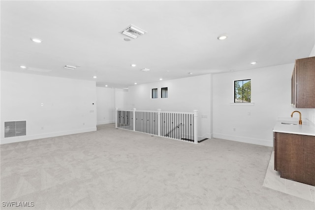 spare room with sink and light colored carpet