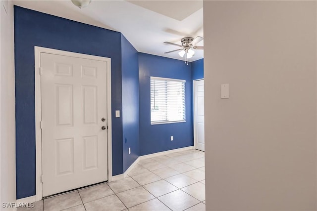 foyer entrance featuring ceiling fan, baseboards, and light tile patterned flooring