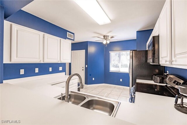 kitchen with sink, ceiling fan, appliances with stainless steel finishes, light tile patterned flooring, and white cabinetry