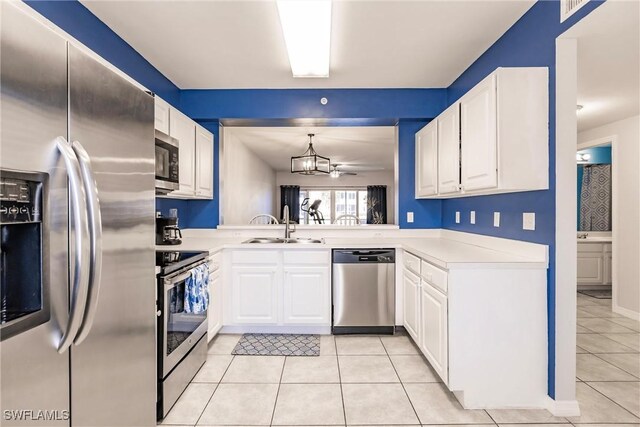 kitchen with white cabinets, sink, light tile patterned floors, decorative light fixtures, and stainless steel appliances