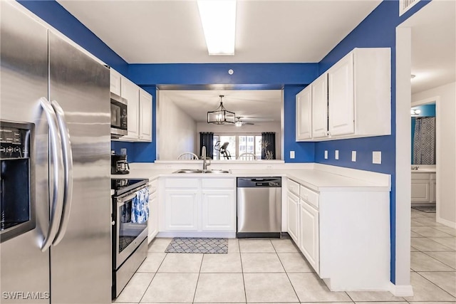 kitchen with stainless steel appliances, light countertops, white cabinetry, pendant lighting, and a sink