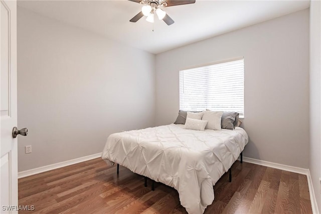 bedroom with ceiling fan, baseboards, and wood finished floors