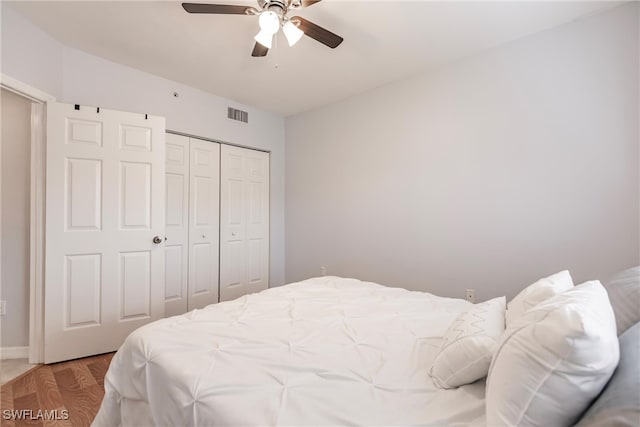 bedroom with hardwood / wood-style floors, a closet, and ceiling fan