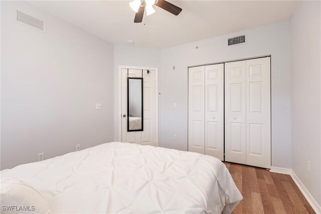 bedroom with light wood-type flooring, a closet, and ceiling fan