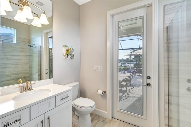 bathroom featuring a healthy amount of sunlight, tiled shower, toilet, and vanity