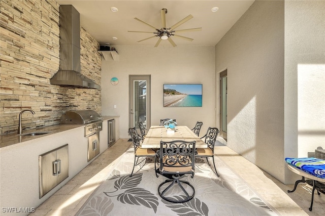 interior space featuring wall chimney exhaust hood, a patio, an outdoor kitchen, ceiling fan, and sink