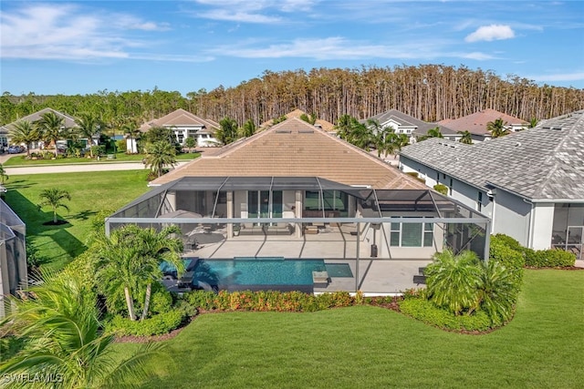 back of property with a patio, a yard, and a lanai