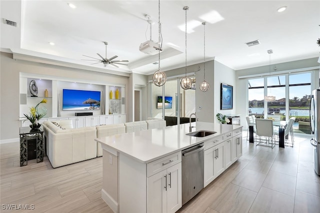 kitchen with stainless steel appliances, ceiling fan, sink, a center island with sink, and white cabinetry