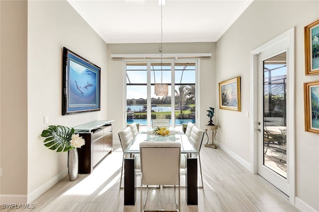 dining room with ornamental molding and a water view