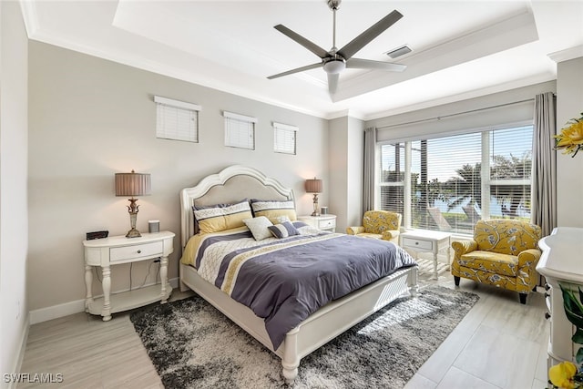 bedroom with ceiling fan, a raised ceiling, and crown molding