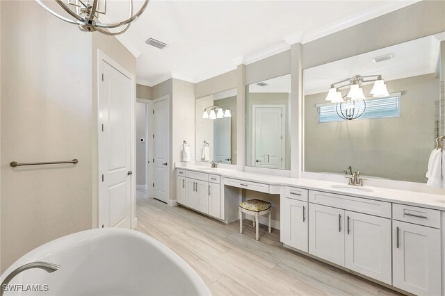 bathroom with an inviting chandelier, a tub to relax in, crown molding, vanity, and hardwood / wood-style flooring