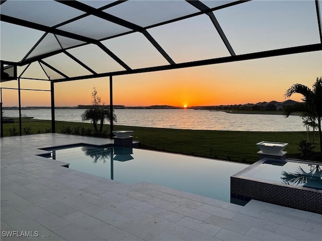 pool at dusk with a patio, a water view, and a lanai