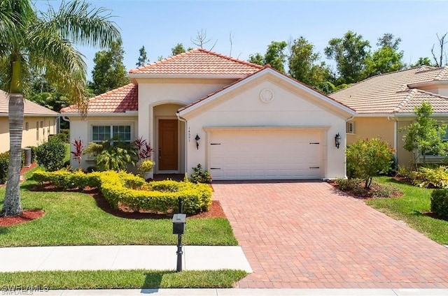 mediterranean / spanish house featuring a garage and a front lawn