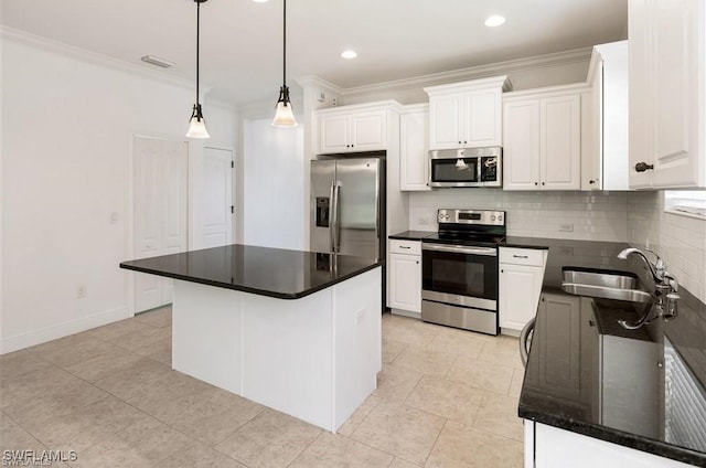 kitchen featuring appliances with stainless steel finishes, sink, pendant lighting, a center island, and white cabinetry