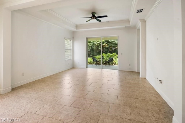 tiled empty room featuring a tray ceiling, ceiling fan, and crown molding