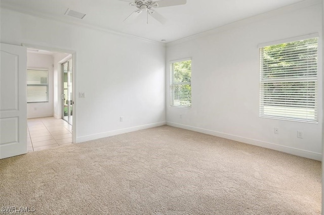 empty room featuring light colored carpet, crown molding, and a wealth of natural light