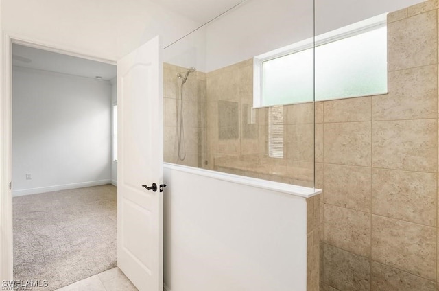 bathroom with tiled shower and tile patterned floors