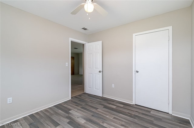 unfurnished bedroom with ceiling fan and dark hardwood / wood-style floors