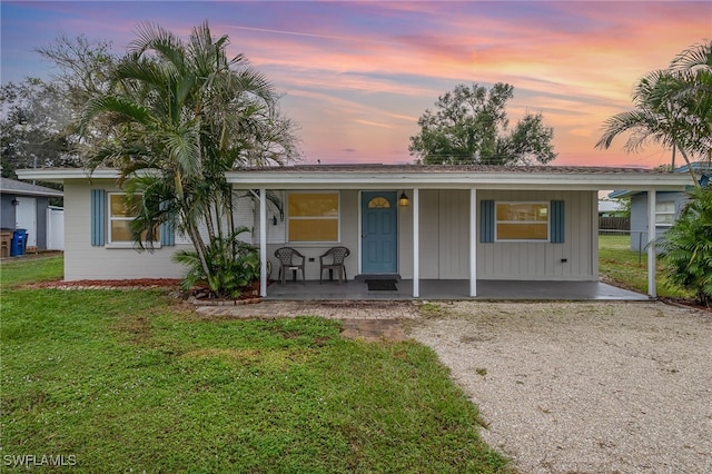 ranch-style home with a lawn and a porch