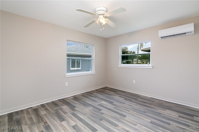 empty room with a wall mounted air conditioner, ceiling fan, and dark hardwood / wood-style flooring