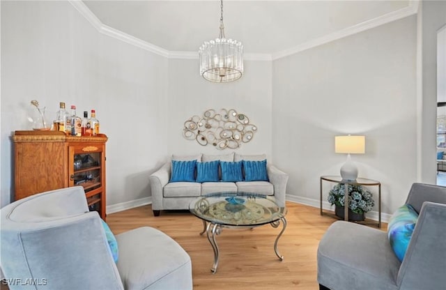 living room with wood-type flooring, crown molding, and an inviting chandelier