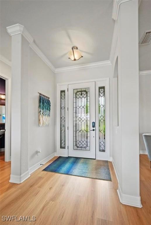 entrance foyer with hardwood / wood-style floors and ornamental molding