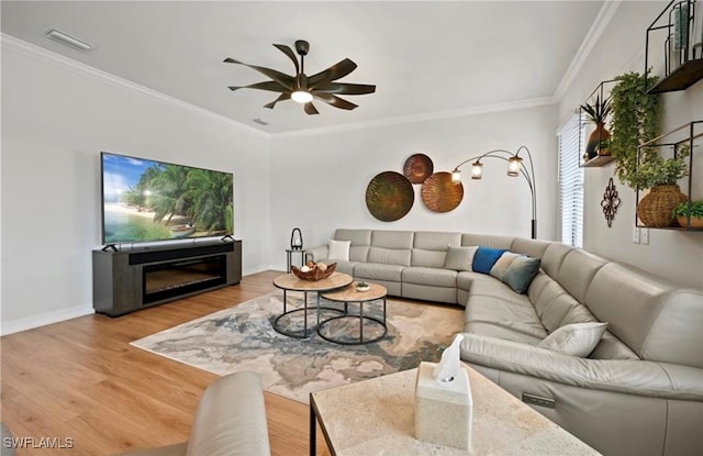 living room with crown molding, ceiling fan, and hardwood / wood-style flooring