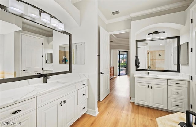 bathroom with walk in shower, crown molding, vanity, and hardwood / wood-style flooring