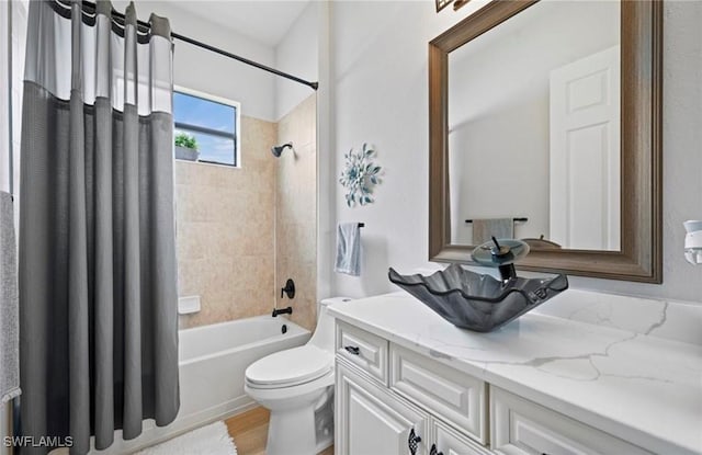 full bathroom with hardwood / wood-style floors, vanity, shower / bath combo, and toilet