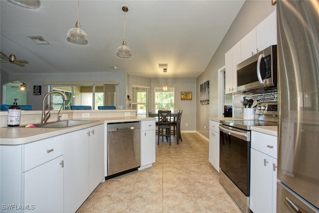 kitchen with appliances with stainless steel finishes, ceiling fan, sink, pendant lighting, and white cabinetry